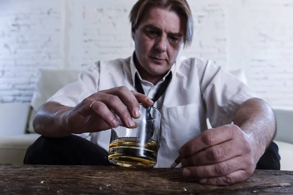 Depressiver alkoholischer Geschäftsmann mit lockerer Krawatte verschwendet und betrunken Whiskey trinkt — Stockfoto