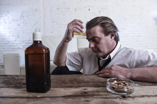 Depressiver alkoholischer Geschäftsmann mit lockerer Krawatte verschwendet und betrunken Whiskey trinkt — Stockfoto