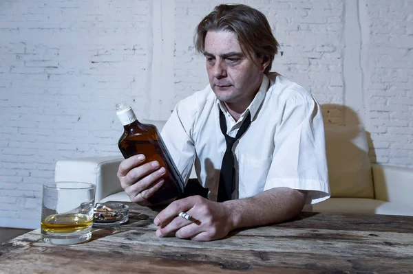 Депрессивный алкогольный бизнесмен с распущенным галстуком, пьяный и пьющий виски — стоковое фото