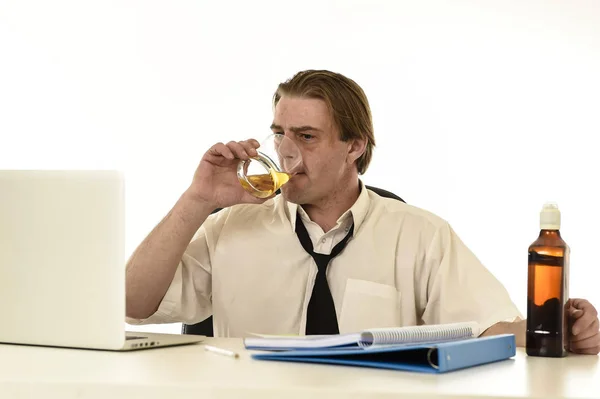 Desperdiciado desordenado alcohólico hombre de negocios beber whisky trabajando en el escritorio de la computadora portátil en la oficina —  Fotos de Stock