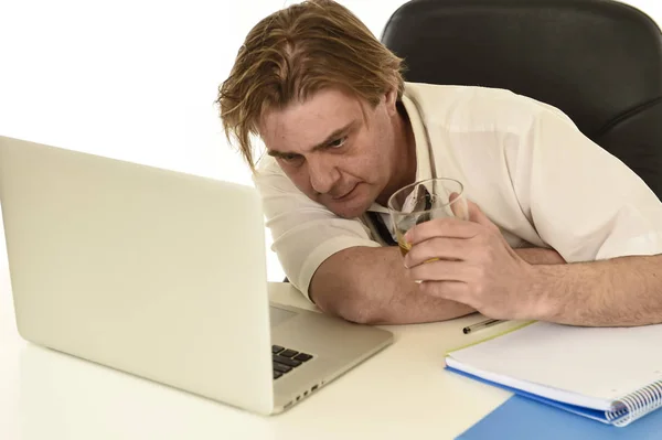 Gaspillé homme d'affaires alcoolique désordonné buvant du whisky travaillant au bureau de l'ordinateur portable au bureau — Photo