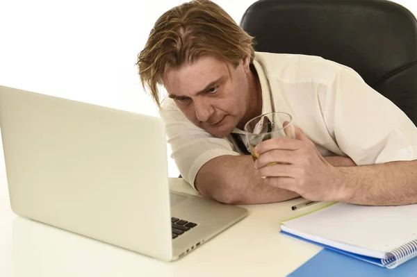 Desperdiciado desordenado alcohólico hombre de negocios beber whisky trabajando en el escritorio de la computadora portátil en la oficina — Foto de Stock