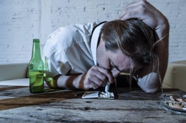 adam kokain burundan enfiye şeklinde çekmek ve bira şişeleri evde içme gevşek kravatla boşa alkolik ve uyuşturucu bağımlısı 