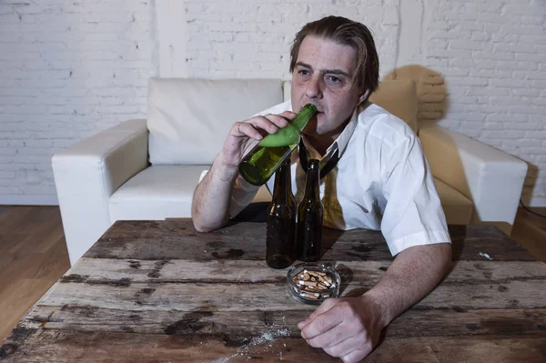 Chaotický alkoholické muž na doma uvázanou vázanku obýváku gauč láhev na pití piva se opít — Stock fotografie