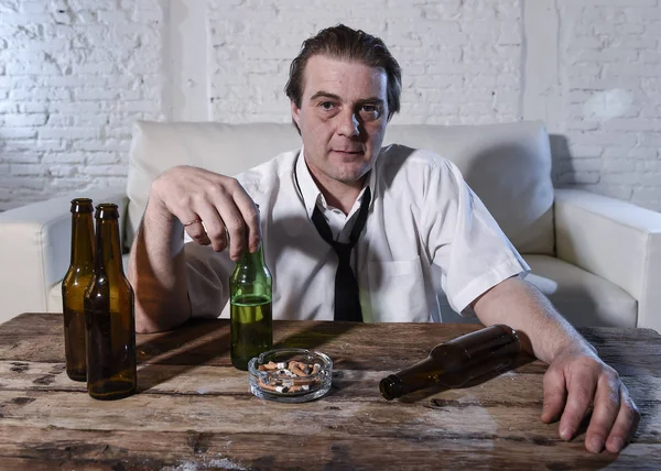 Hombre alcohólico desordenado en corbata suelta en casa sala de estar sofá beber botella de cerveza emborracharse —  Fotos de Stock