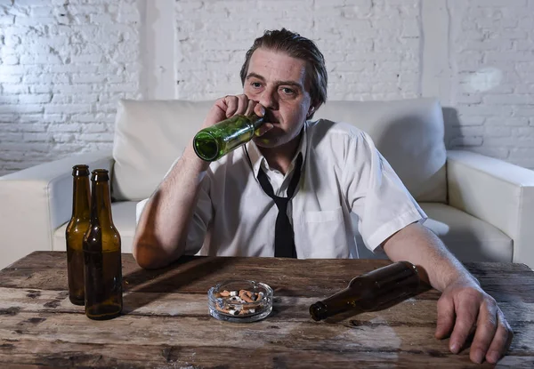 Homme alcoolique désordonné sur cravate lâche à la maison salon canapé boire bouteille de bière se saouler — Photo