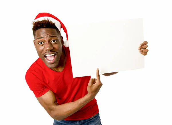 Schwarzer afroamerikanischer Mann mit Weihnachtsmannhut lächelt glücklich und zeigt leere Plakatwand Kopierraum — Stockfoto