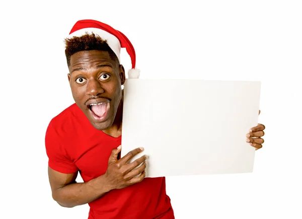 Черный афро-американец в рождественской шляпе Санта улыбается счастливо показывая пустое пространство для копирования рекламного щита — стоковое фото