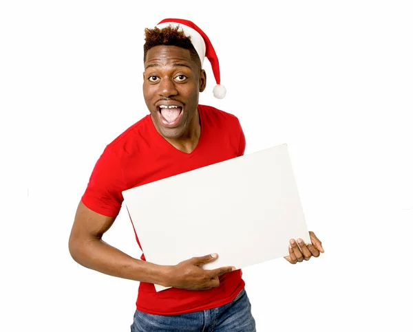 Schwarzer afroamerikanischer Mann mit Weihnachtsmannhut lächelt glücklich und zeigt leere Plakatwand Kopierraum — Stockfoto