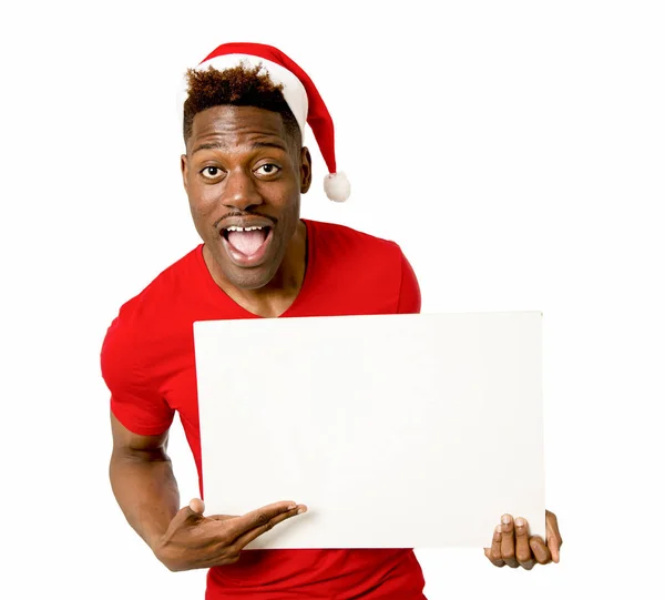 Negro afro americano hombre en Navidad santa sombrero sonriendo feliz mostrando espacio de copia de la cartelera en blanco —  Fotos de Stock