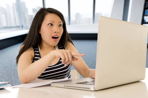 Feliz chino asiático mujer trabajando y estudiando en su ordenador sentado en moderno oficina escritorio sonriendo alegre —  Fotos de Stock