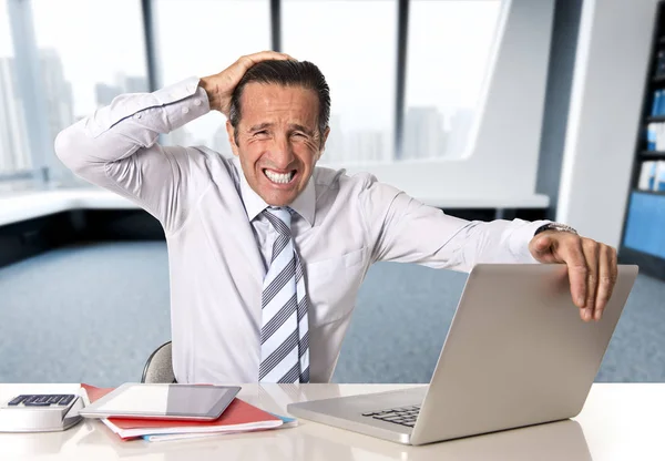 Desesperado empresario senior en crisis trabajando en computadora portátil en escritorio de oficina en estrés bajo presión —  Fotos de Stock