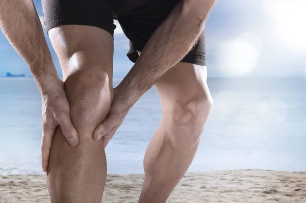 Jeune homme de sport avec des jambes athlétiques tenant genou dans la douleur souffrant de blessures musculaires courir — Photo