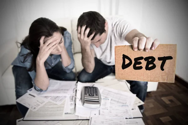 对夫妇担心需要帮助家庭的压力，在沙发上会计债务票据银行文件费用和付款 — 图库照片