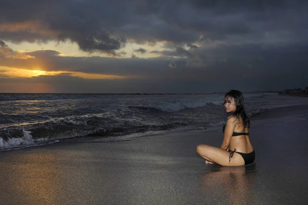genç güzel ve seksi Asyalı kadın siyah bikini poz içinde günbatımı Plajı Endonezya Bali Adası'nda eğleniyor rahat