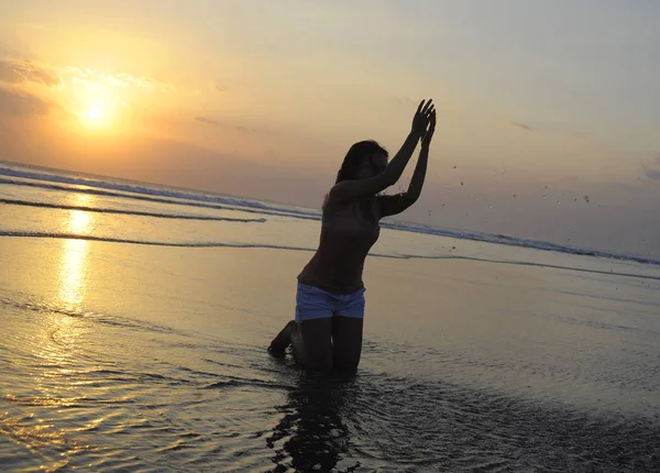 Siluet wanita muda Asia bermain dengan pasir dan air di laut saat matahari terbenam pantai bahagia dan bersemangat — Stok Foto