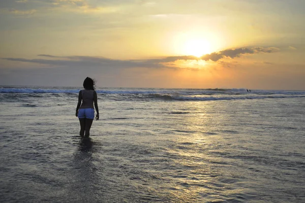 Jonge vrouw mediteren en vreedzaam denken over verlaten strand op zonsondergang in meditatie en vrijheid — Stockfoto