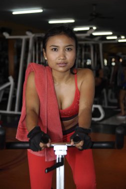 sabit Bisiklet ve spor salonunda egzersiz statik bisiklet sürme eğitim genç güzel ve terli Asya aktif kadın