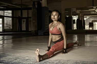 sert grunge Düzenle genç terli Asyalı kadın spor giysiler rahatlamak için germe ve split bacak kasları