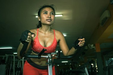 sabit Bisiklet ve spor salonunda egzersiz statik bisiklet sürme eğitim genç güzel ve terli Asya aktif kadın