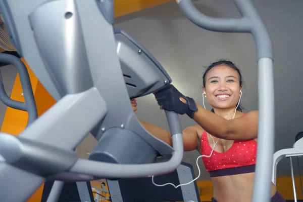 Sexy i spocona Asian kobieta ciężko trenują w siłowni przy użyciu eliptyczne pedałowania maszyny sprzęt w intensywnym treningu — Zdjęcie stockowe