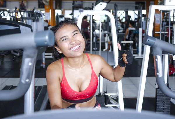 Sexy y sudorosa mujer asiática entrenando duro en el gimnasio usando equipo de máquina de pedaleo elíptico en entrenamiento intenso — Foto de Stock