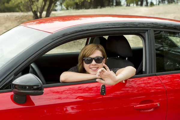 Mulher atraente sorrindo orgulhoso sentado no assento do motorista segurando e mostrando chave do carro na compra de automóveis novos e alugando — Fotografia de Stock
