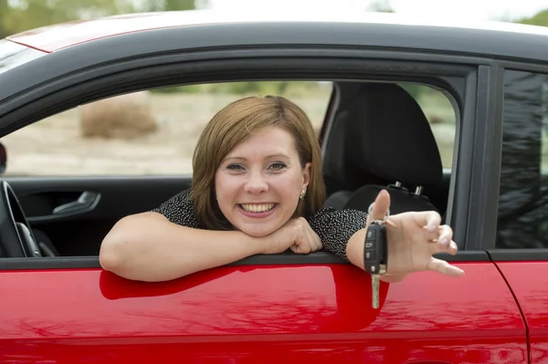 Mulher atraente sorrindo orgulhoso sentado no assento do motorista segurando e mostrando chave do carro na compra de automóveis novos e alugando — Fotografia de Stock