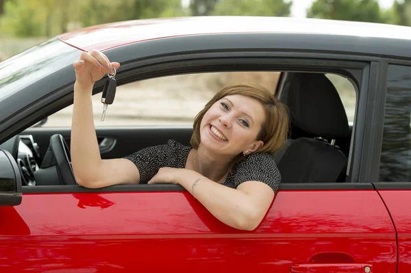 Mulher atraente sorrindo orgulhoso sentado no assento do motorista segurando e mostrando chave do carro na compra de automóveis novos e alugando — Fotografia de Stock