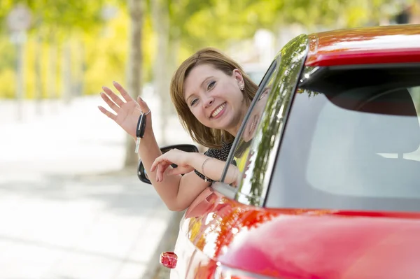 Mulher atraente sorrindo orgulhoso sentado no assento do motorista segurando e mostrando chave do carro na compra de automóveis novos e alugando — Fotografia de Stock