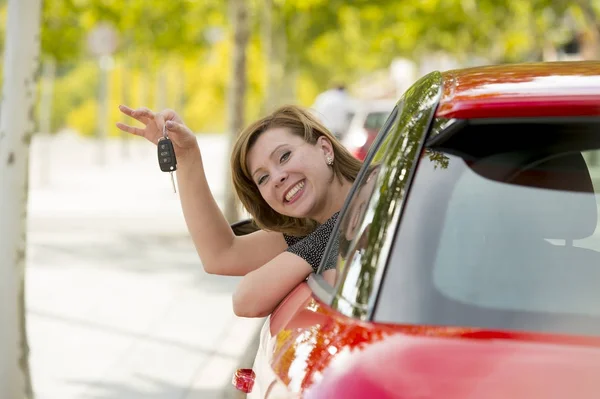 Mulher atraente sorrindo orgulhoso sentado no assento do motorista segurando e mostrando chave do carro na compra de automóveis novos e alugando — Fotografia de Stock