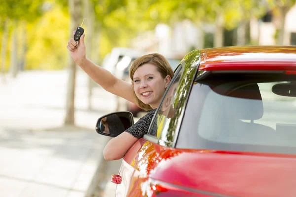 Mulher atraente sorrindo orgulhoso sentado no assento do motorista segurando e mostrando chave do carro na compra de automóveis novos e alugando — Fotografia de Stock