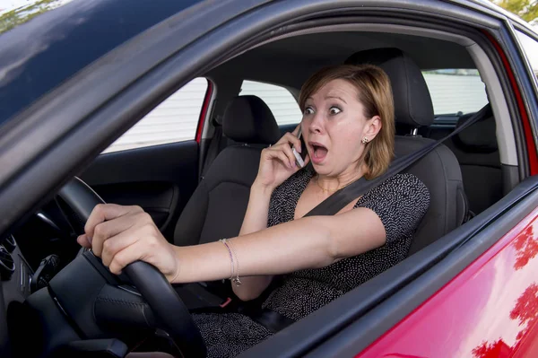 Hermosa mujer conduciendo coche, mientras que los mensajes de texto utilizando el teléfono móvil distraído — Foto de Stock