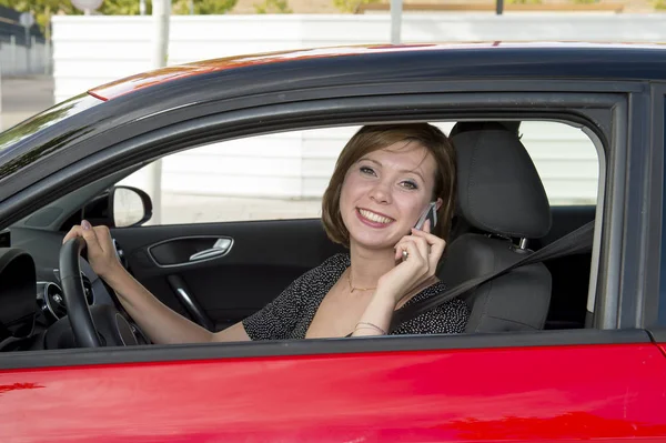 Mulher falando feliz no telefone celular enquanto segurando carro volante condução distraído — Fotografia de Stock
