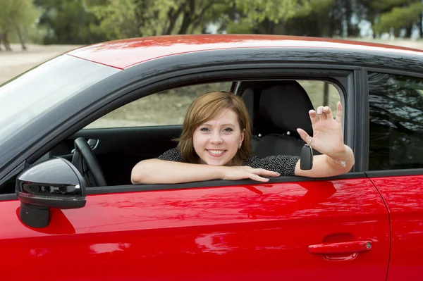 Mulher atraente feliz sentado no assento do motorista sorrindo alegre e orgulhoso acenando Olá de carro novo — Fotografia de Stock