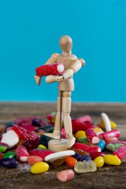 kukla kukla holding ve meyan kökü ve karamel gummies üzerine tatlı şeker taşıma 