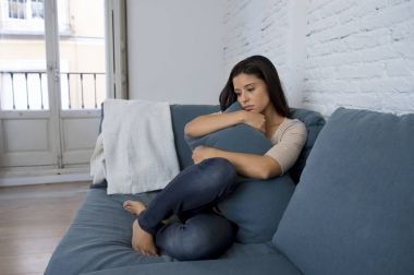 genç çekici latin kadın evde kanepe depresyon duygu üzgün ve umutsuz acı endişeli yalan