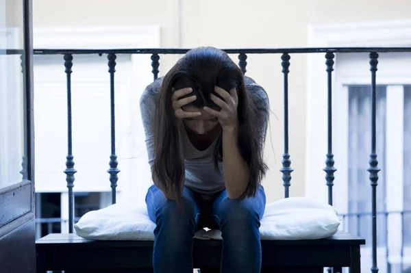 Wanita Latin putus asa duduk di balkon rumah tampak hancur dan depresi — Stok Foto