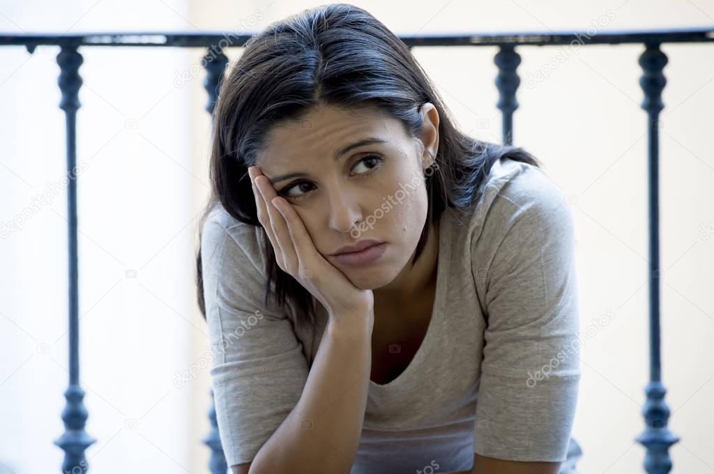 desperate Latin woman sitting at home balcony looking destroyed and depressed suffering depression