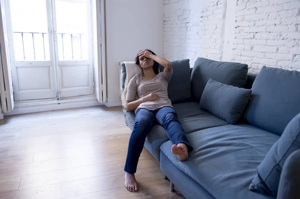 Joven atractivo latino mujer acostado en casa sofá preocupado sufrimiento depresión sentirse triste y desesperado —  Fotos de Stock