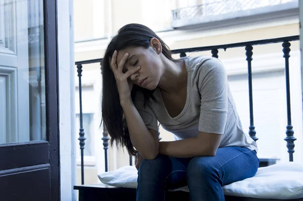 Zdesperowany Łacińska kobieta siedzi w domu balkonem patrząc zniszczone i przygnębiony, cierpienie depresja — Zdjęcie stockowe