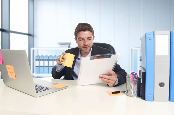 young attractive businessman working happy confident at office with laptop computer and paperwork