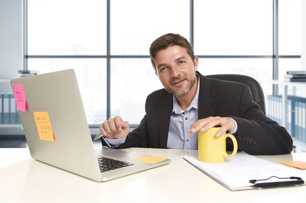 young attractive businessman working happy confident at office with laptop computer and paperwork