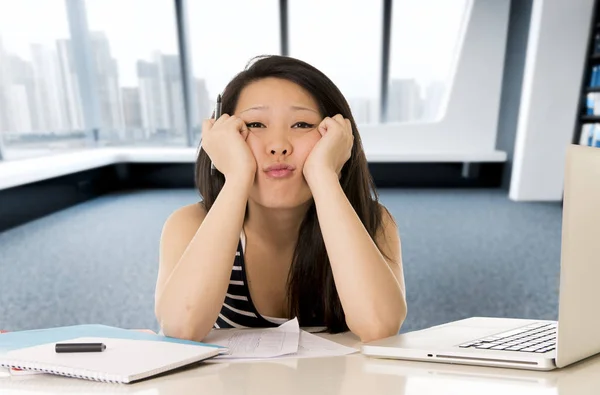 Chinese asian student or business woman bored tired working and studying on computer laptop — Stock Photo, Image