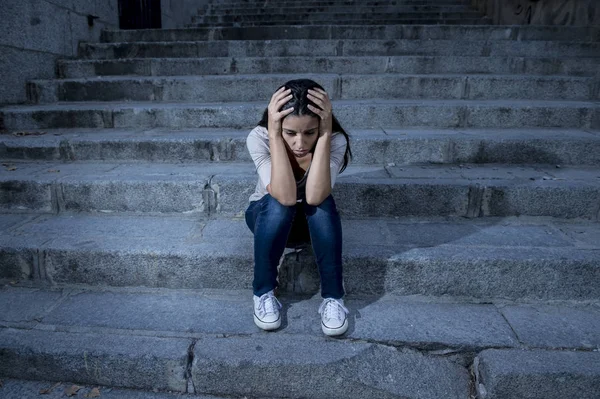絶望的な都市通りの階段の上に座って意気消沈した、ヒスパニック系女性の美しくも悲しい — ストック写真