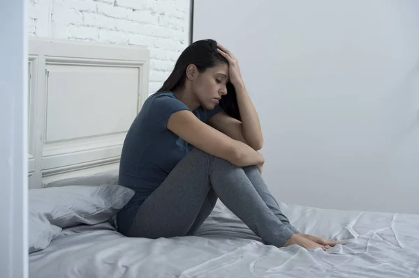 Hermosa mujer latina triste y deprimida sentada en la cama en casa frustrado sufrimiento depresión —  Fotos de Stock