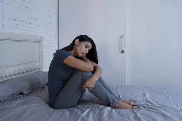 Mooie triest en depressief-Latijnse vrouw zittend op bed thuis f — Stockfoto