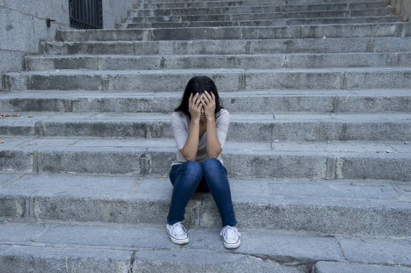 Schöne und traurige hispanische Frau verzweifelt und deprimiert auf der städtischen Straßentreppe sitzend — Stockfoto