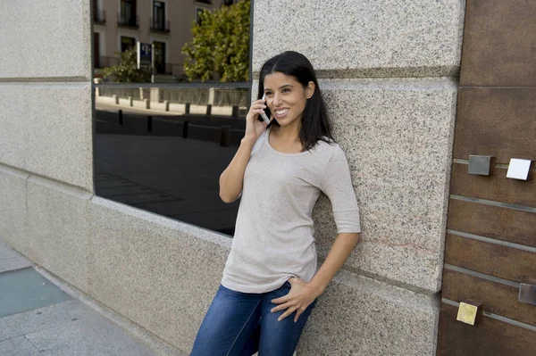 Gelukkig mooi en aantrekkelijk Latijns jongedame praten op mobiele telefoon op straat in de stad — Stockfoto