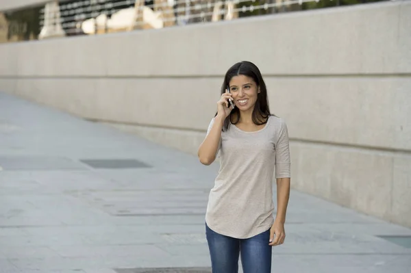 Gelukkig Latijns-vrouw op stedelijke straat stad achtergrond praten op mobiele telefoon met een zoete glimlach — Stockfoto